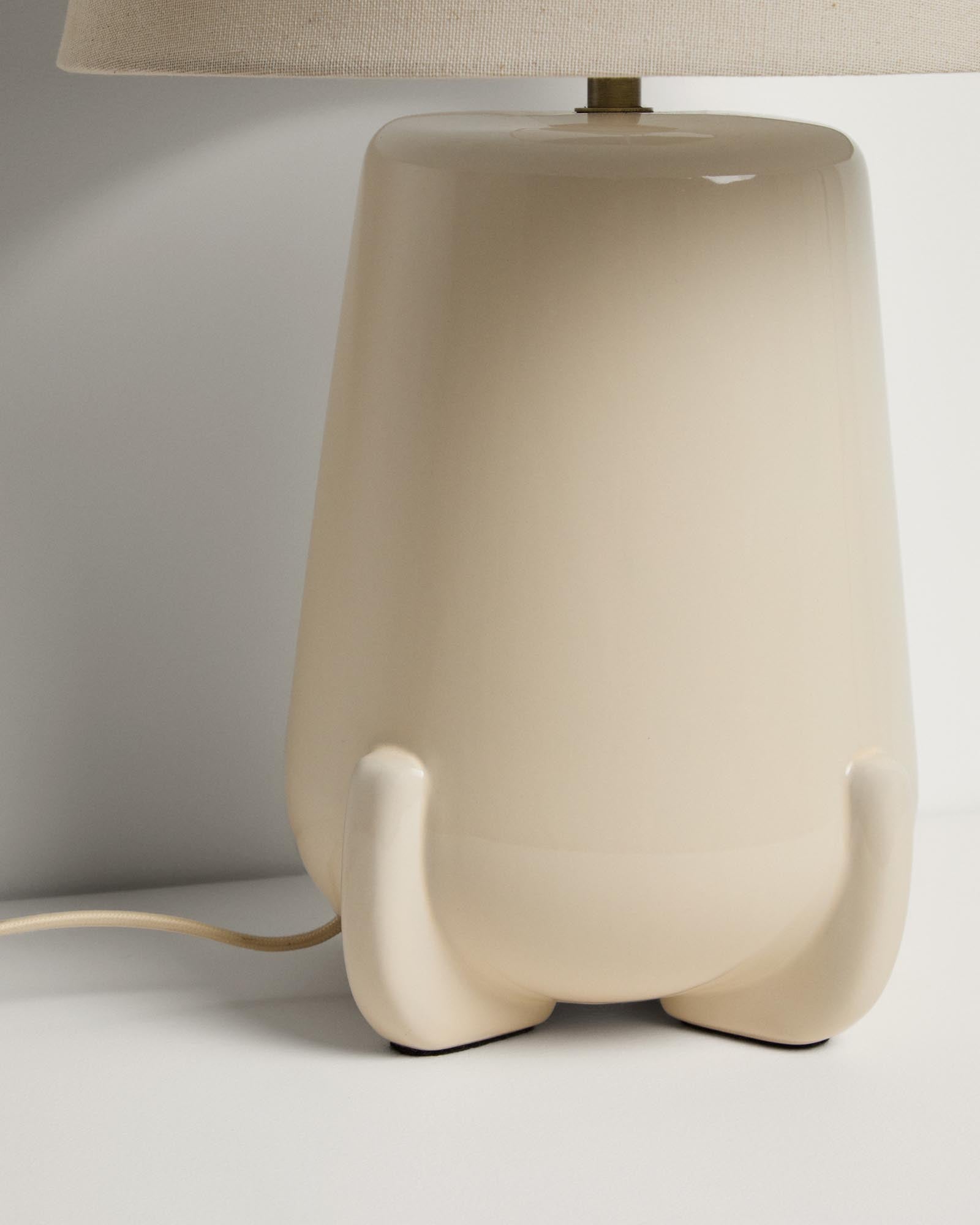 Elegante Tischlampe Odra aus ecrufarbener Keramik mit glänzender Oberfläche, ideal für eine geschmackvolle Beleuchtung in jedem Raum.