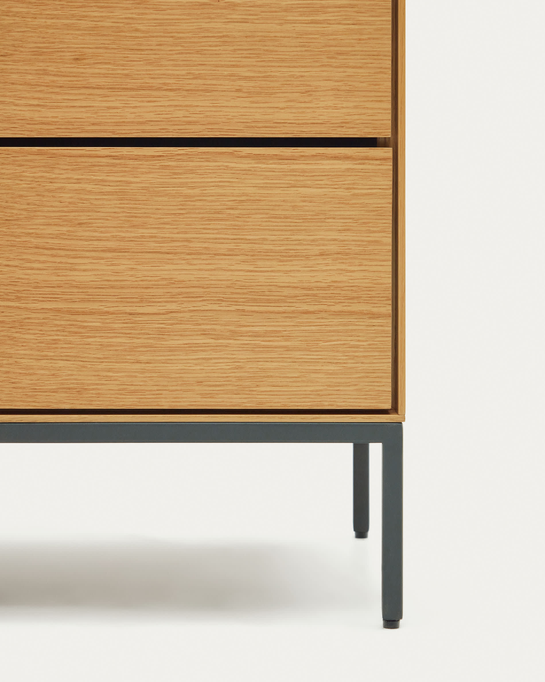 Die Vedrana Kommode von Kave Home vereint modernes Design mit Funktionalität. Eichenfurnier und schwarze Stahlbeine bieten stilvollen Stauraum.