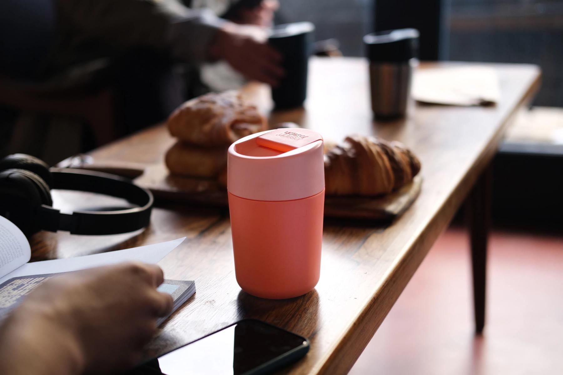 Stylischer Sipp Travel Mug in strahlendem Koralle (340ml) von Joseph Joseph, perfekt für unterwegs und für heiße Getränke.