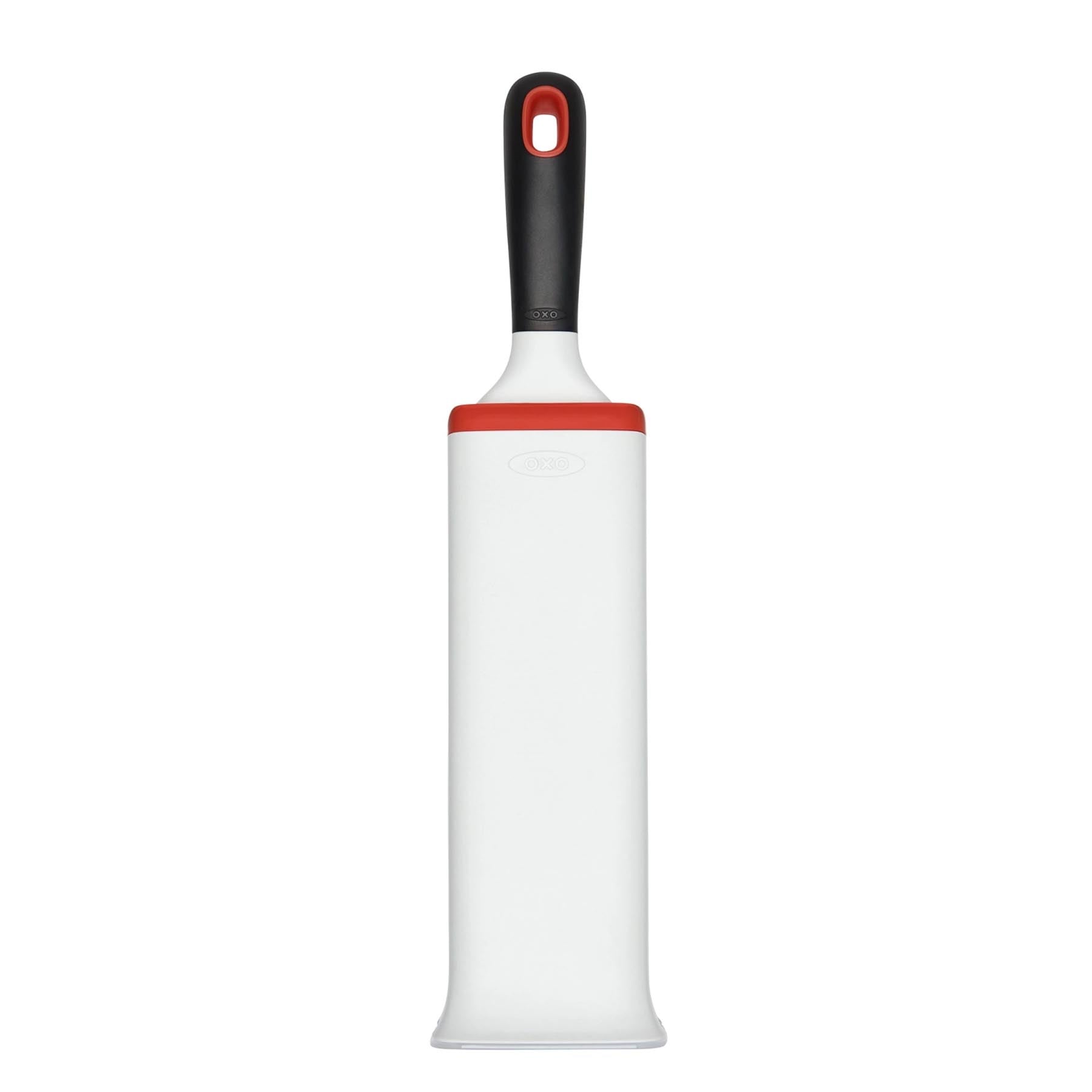Praktische GG Flusenentferner Bürste in Weiß-Orange von OXO, ideal zur schnellen Entfernung von Fusseln und Tierhaaren von Möbeln.