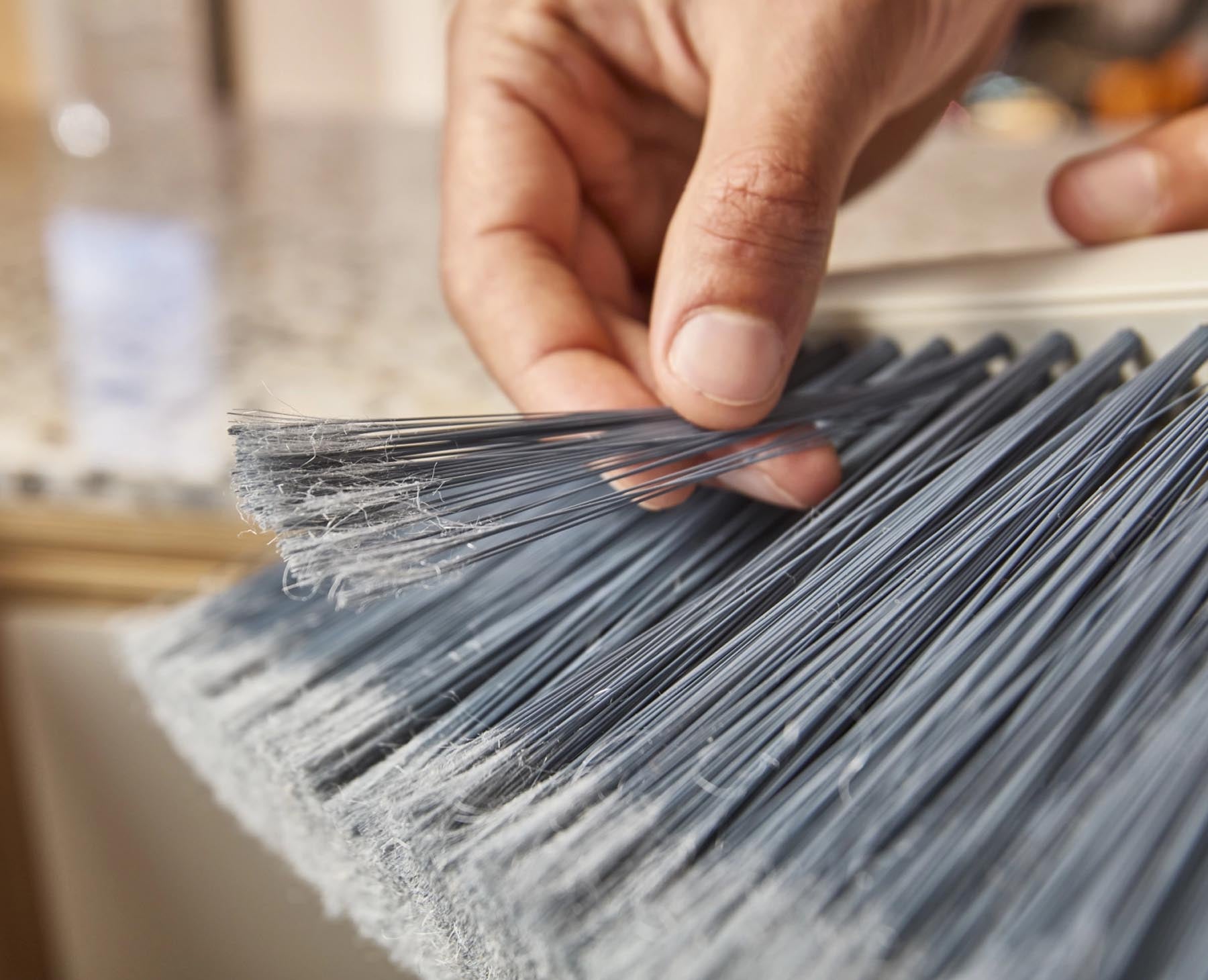 Stylischer CleanTech Besen in modernem Steinfarbton, ausgestattet mit praktischer Wandhalterung für eine ordentliche Aufbewahrung und effiziente Reinigung.