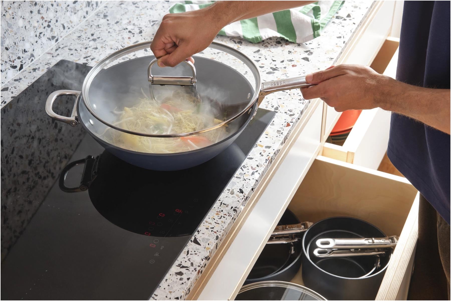 Eleganter 32 cm Wok aus Edelstahl mit klappbarem Griff und antihaftbeschichtetem Deckel, ideal für vielseitige Kochtechniken.