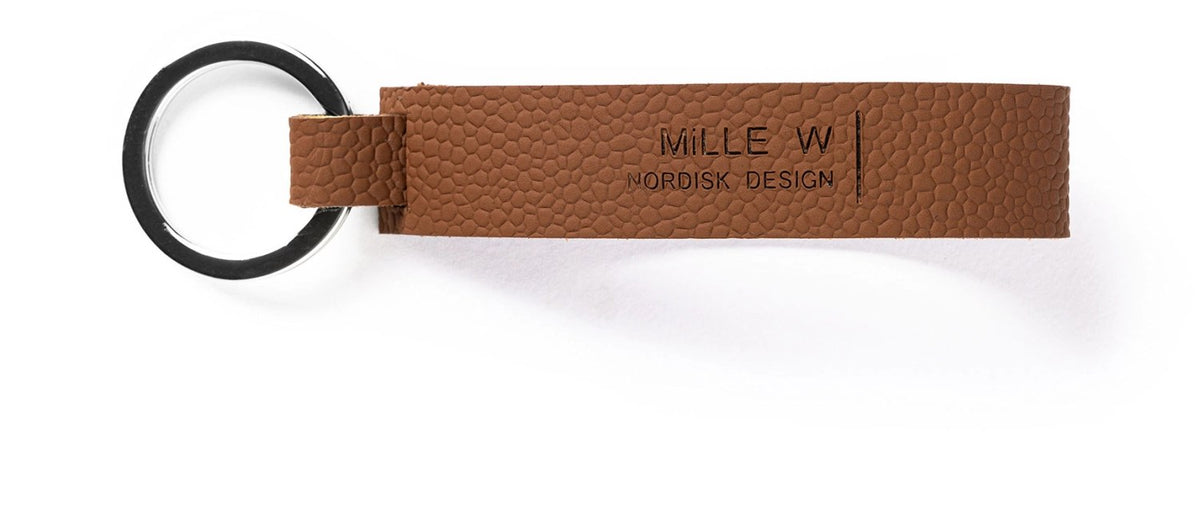 Foto des Schlüsselanhängers classic nickel cognac von MiLLE W NORDISK DESIGN in Braun, Masse 8 x 2 x 0.2 cm, aus der Alchemy Serie Churchill.