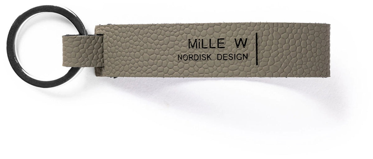 Grauer Schlüsselanhänger classic nickel grau von MiLLE W NORDISK DESIGN, flache rechteckige Form, Masse 8 x 2 x 0.2 cm.