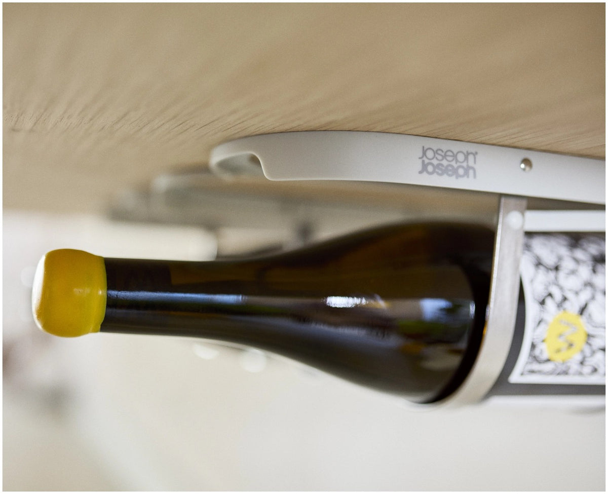Klappbarer Weinflaschenhalter aus Edelstahl in Hellgrau, montiert unter einem Küchenschrank, mit Platz für vier Flaschen und Magnetverschluss.