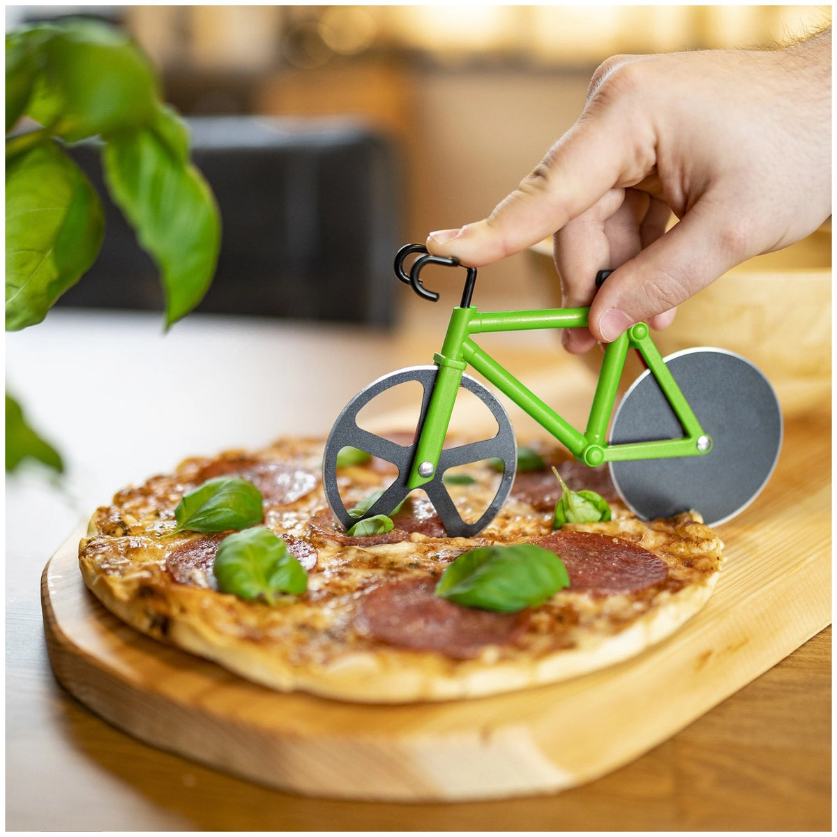 Graues Display mit neun Pizzaschneidern der Serie Fuentez von Westmark, Fahrrad-Form mit Rädern in Gelb, Grün und Rot, auf Ständer stehend.