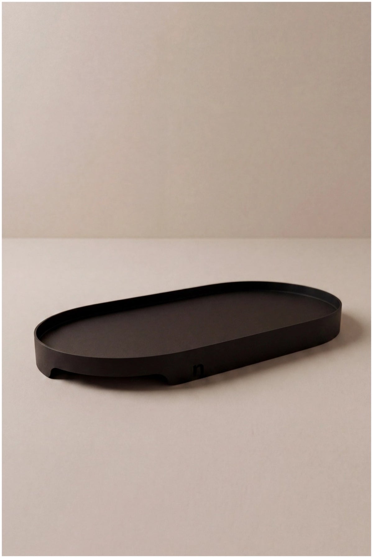 Ovales Tablett aus schwarzem Metall, Masse 21x11x1.8cm, glatte matte Oberfläche, schlichtes Design von Nordesign, freigestellt fotografiert.