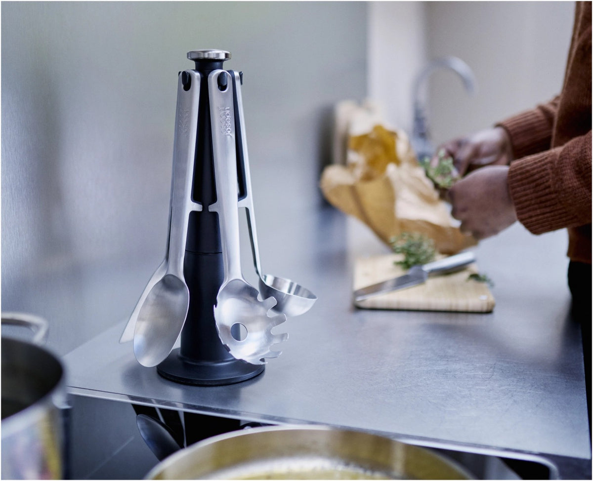 5-teiliges Utensilienhalter-Set aus Edelstahl in Silber: Kochlöffel, Schlitzwender, Spaghettizange, Schöpfkelle, Grillzange auf drehbarem Karussell.