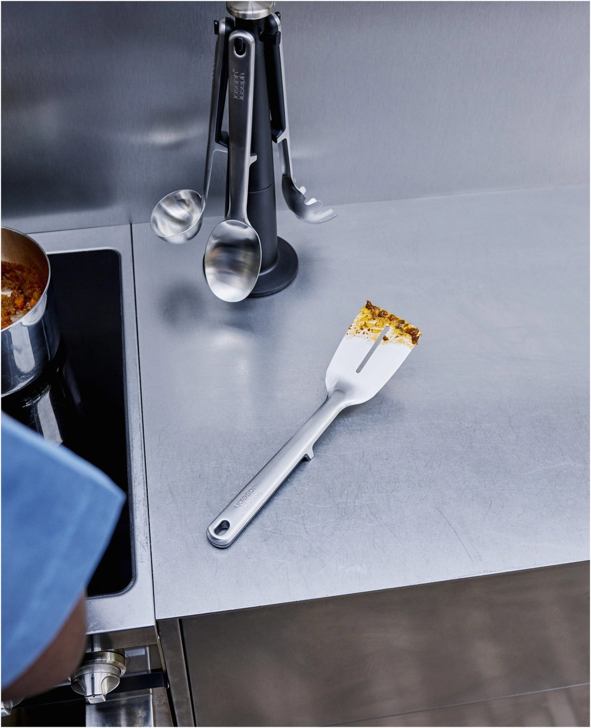 5-teiliges Utensilienhalter-Set aus Edelstahl in Silber: Kochlöffel, Schlitzwender, Spaghettizange, Schöpfkelle, Grillzange auf drehbarem Karussell.