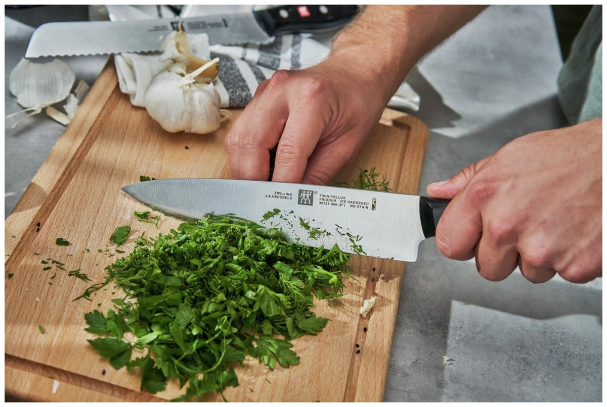 Zwilling Signature Kochmesser mit 20 cm langer Edelstahlklinge und schwarzem Griff im Drei-Nieten-Design, freigestellt fotografiert.