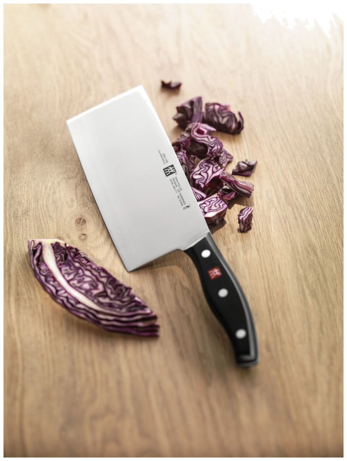 Zwilling Signature Kochmesser mit 18cm hoher Klinge aus Edelstahl, Griff im Drei-Nieten-Design, mehrfarbige Optik, Ansicht von der Seite.