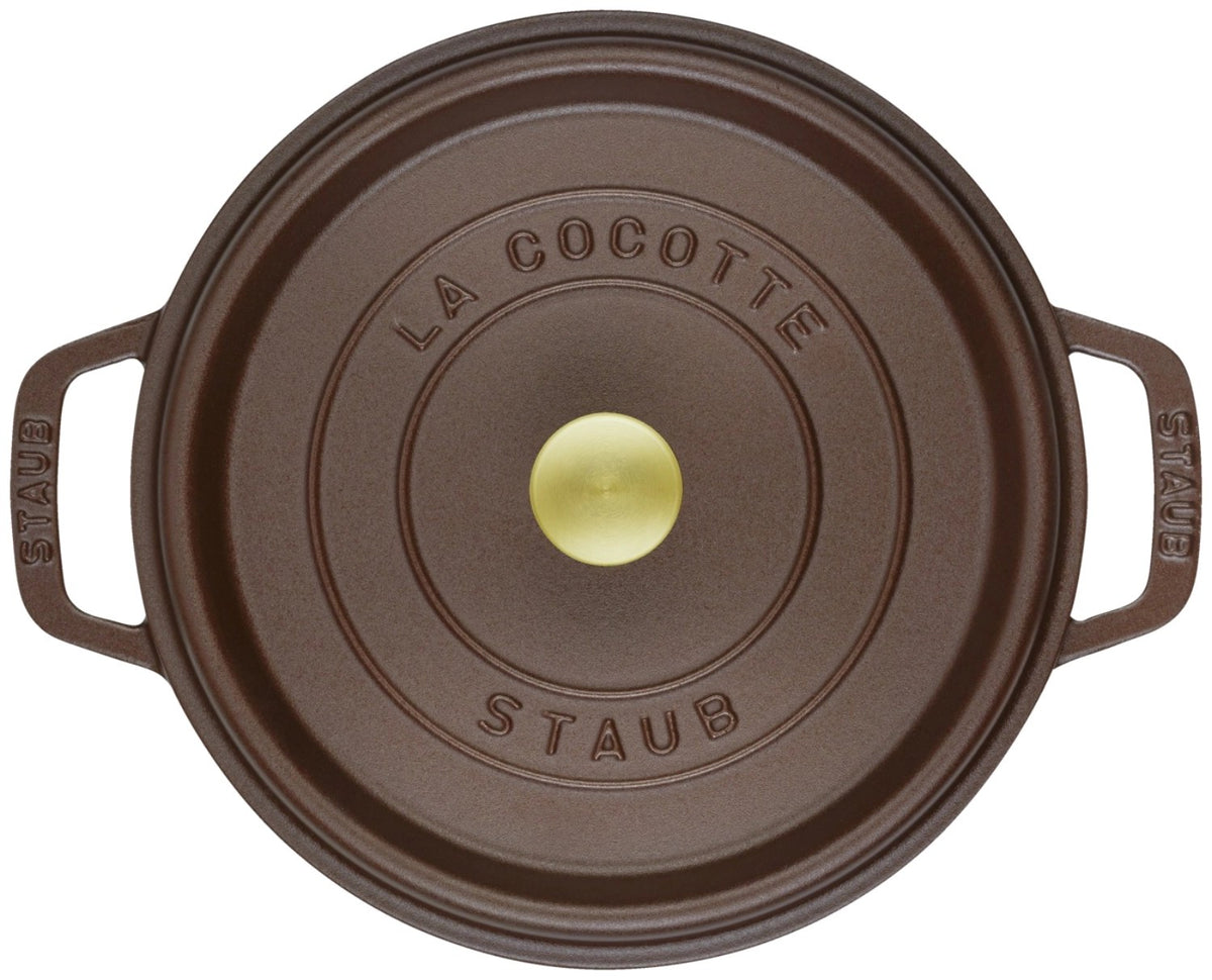 Runde Staub Cocotte aus Gusseisen in der Farbe Chocolat, 24 cm Durchmesser, mit Deckel, emaillierte matte Oberfläche, freigestellt fotografiert.
