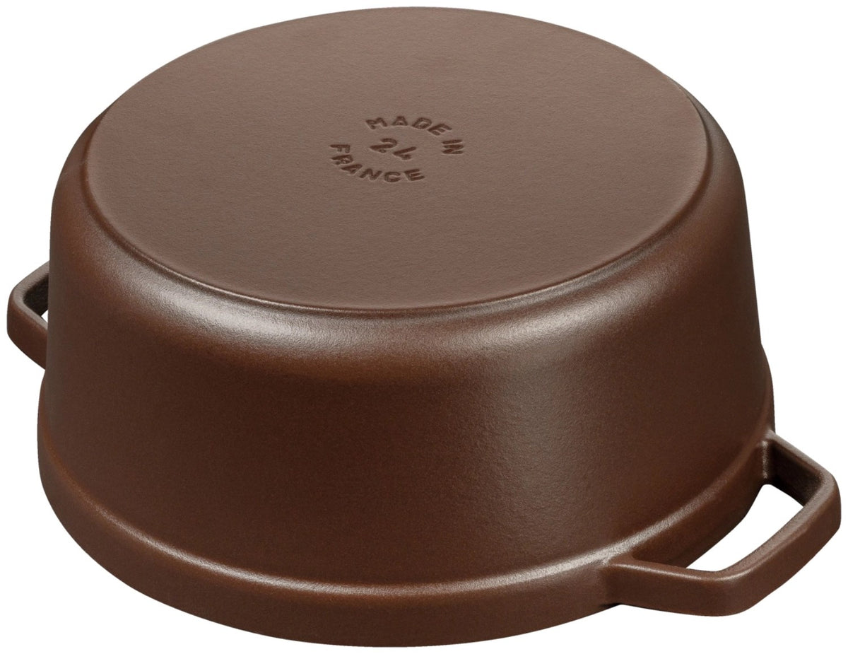 Runde Staub Cocotte aus Gusseisen in der Farbe Chocolat, 24 cm Durchmesser, mit Deckel, emaillierte matte Oberfläche, freigestellt fotografiert.