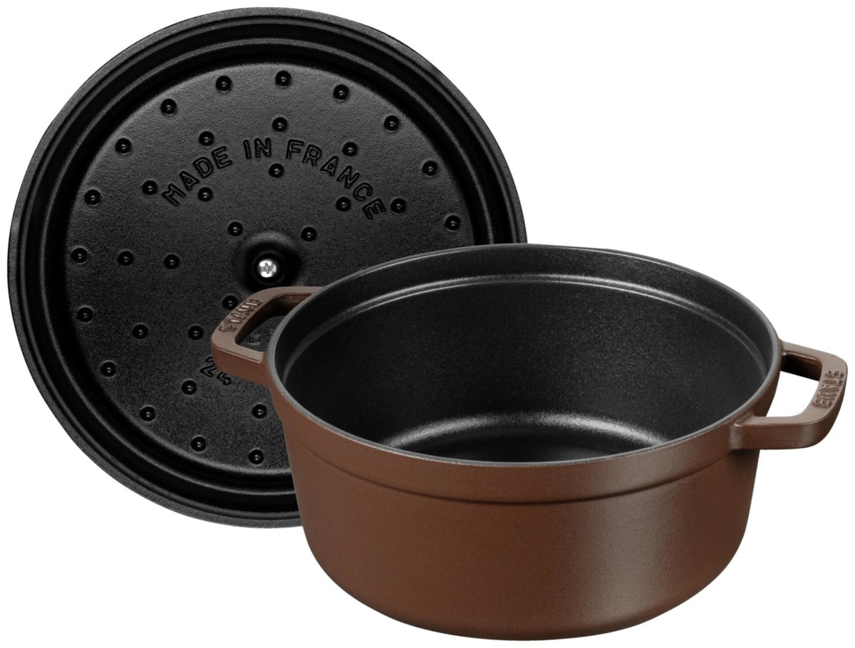 Runde Staub Cocotte aus Gusseisen in der Farbe Chocolat, 24 cm Durchmesser, mit Deckel, emaillierte matte Oberfläche, freigestellt fotografiert.