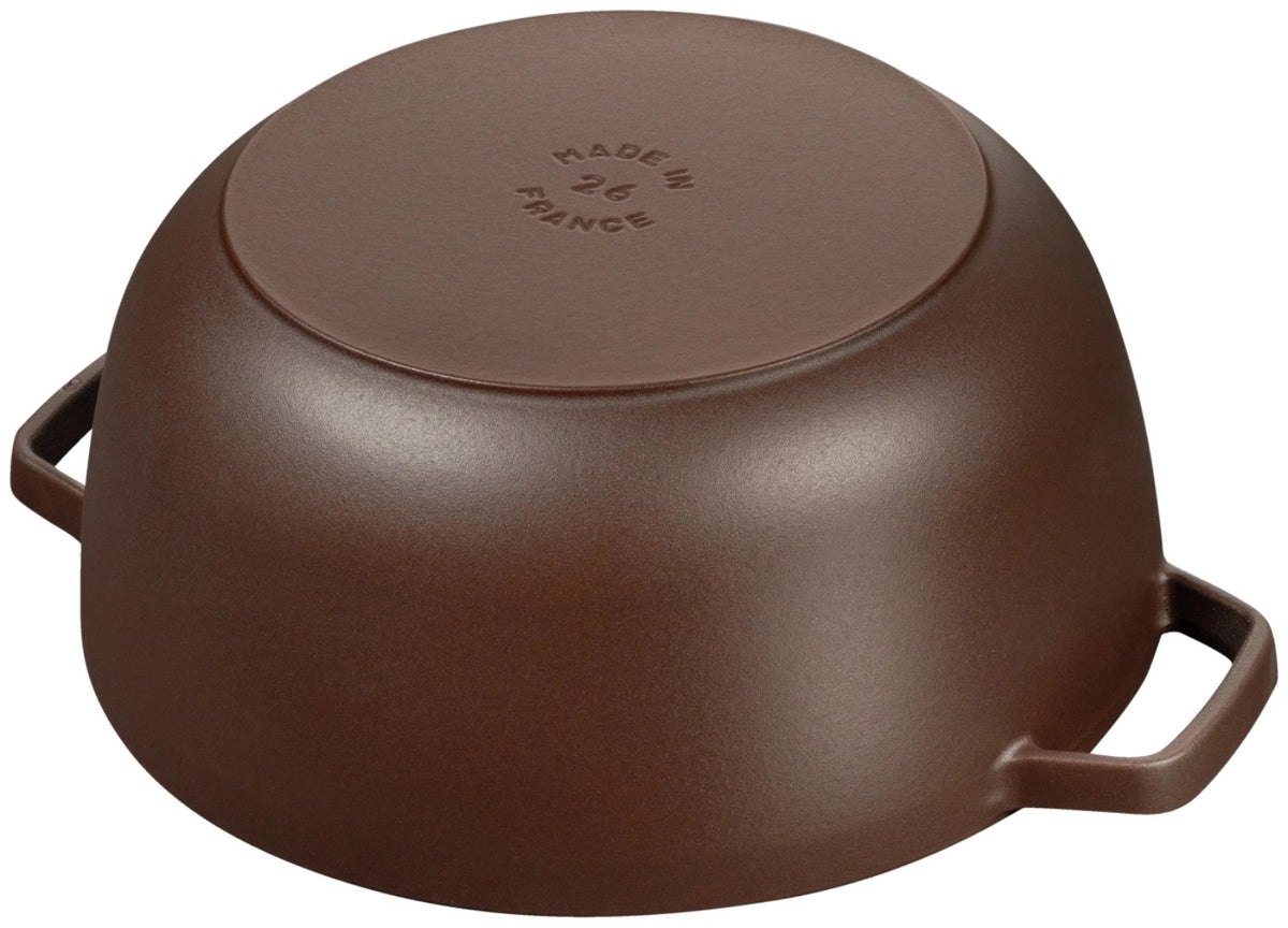 Braune gusseiserne Cocotte mit Deckel in ovaler bzw. runder Form, glänzend emaillierte Oberfläche, seitliche Grifflaschen am Topfkörper.