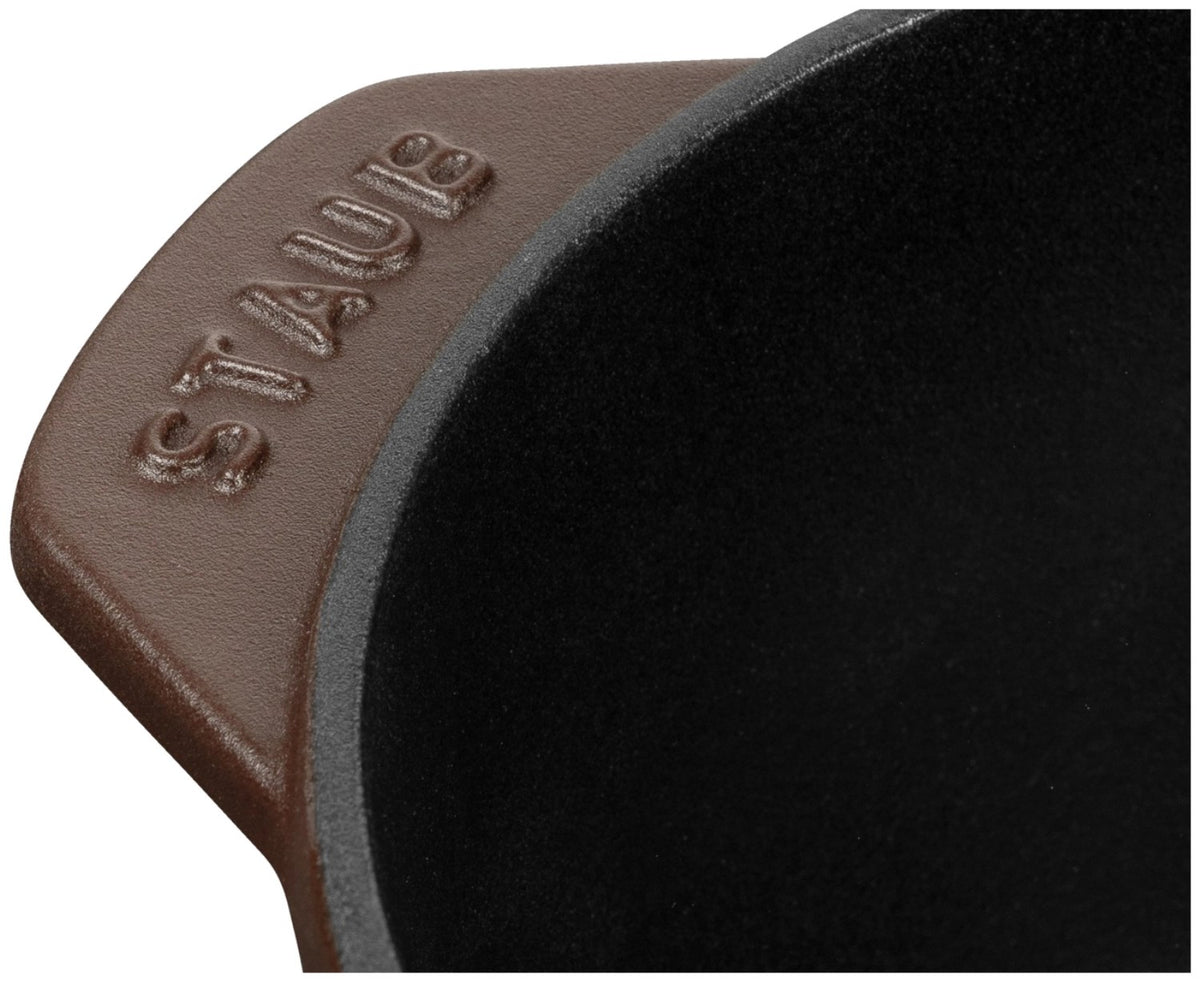 Braune Cocotte aus Gusseisen mit Deckel, rund, 16 cm Durchmesser, matte Chocolat-Farbe, Staub Kochgeschirr auf hellem Hintergrund.