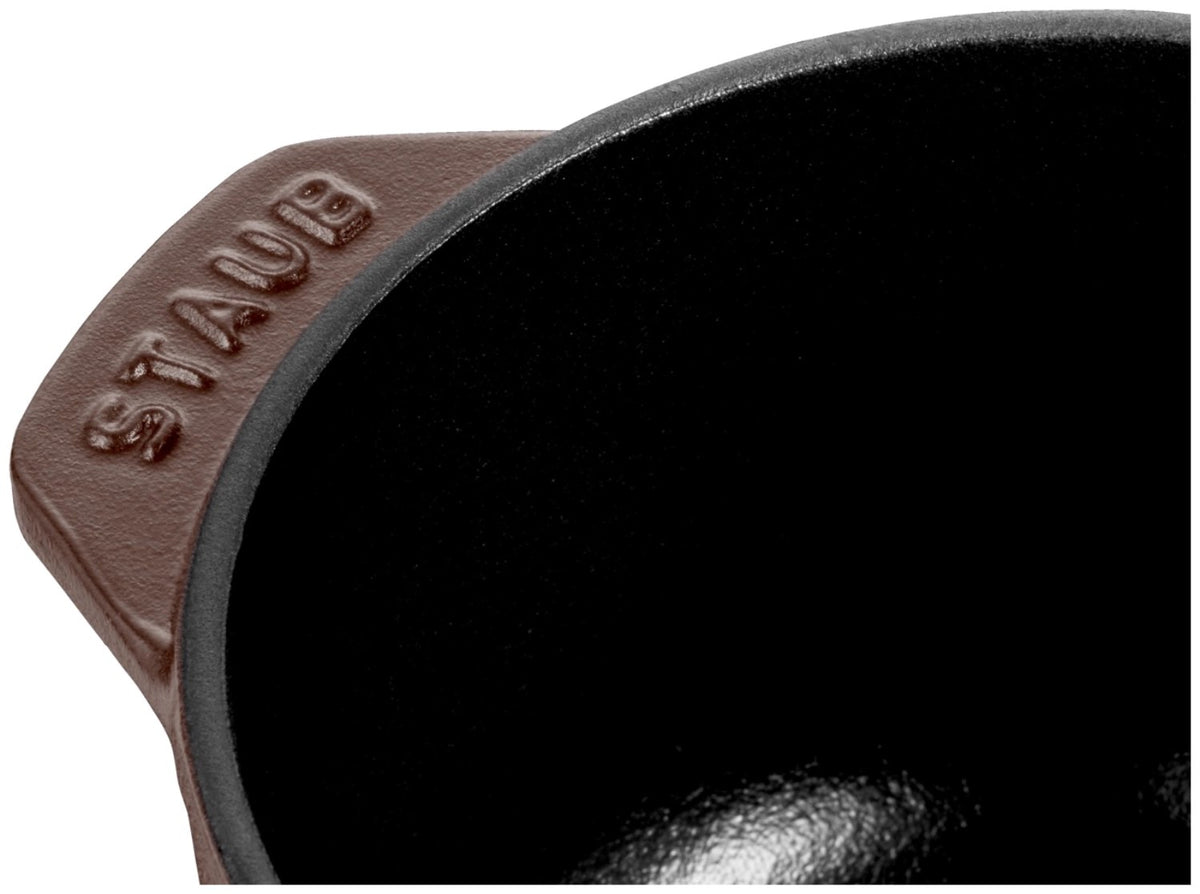 Braune Cocotte aus emailliertem Gusseisen von Staub, rund, mit Deckel, Grösse 20cm, Ansicht von schräg oben auf der Arbeitsfläche.