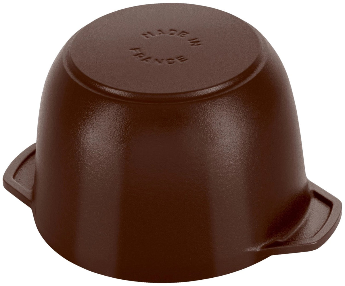 Braune Cocotte aus emailliertem Gusseisen von Staub, rund, mit Deckel, Grösse 20cm, Ansicht von schräg oben auf der Arbeitsfläche.