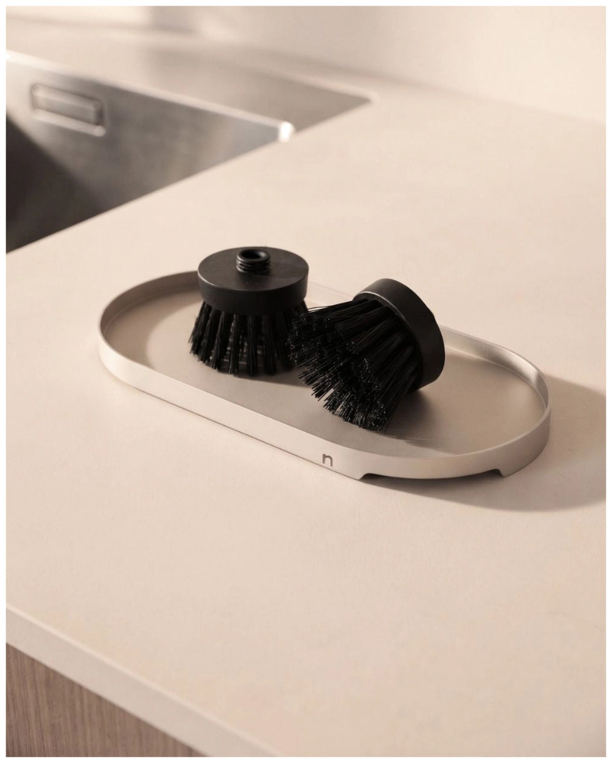 Schwarze Spülbürste aus Kunststoff von Nordesign mit schlankem Griff, wechselbarem Bürstenkopf und integriertem Magnet an der Unterseite.