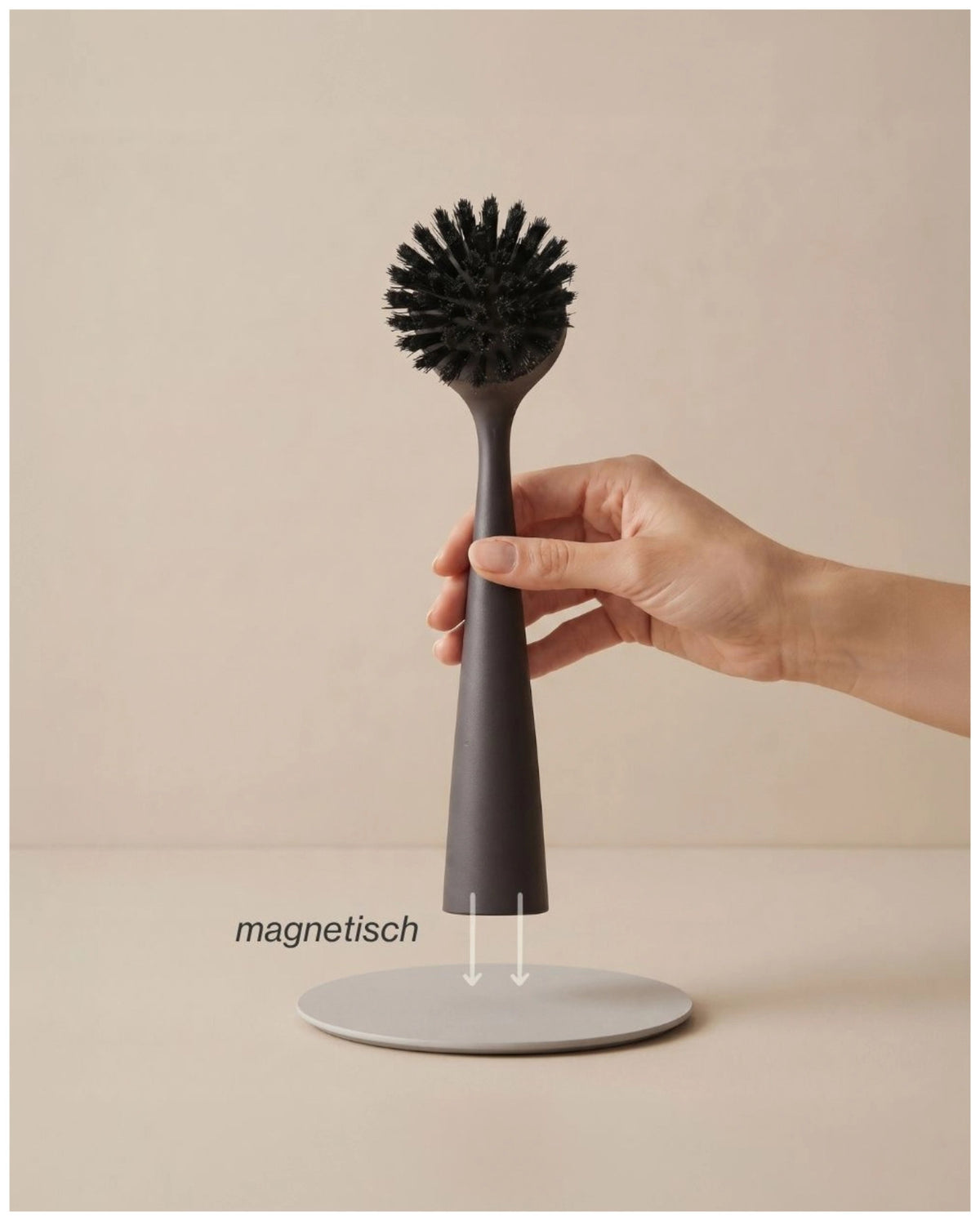 Schwarze Spülbürste aus Kunststoff von Nordesign mit schlankem Griff, wechselbarem Bürstenkopf und integriertem Magnet an der Unterseite.