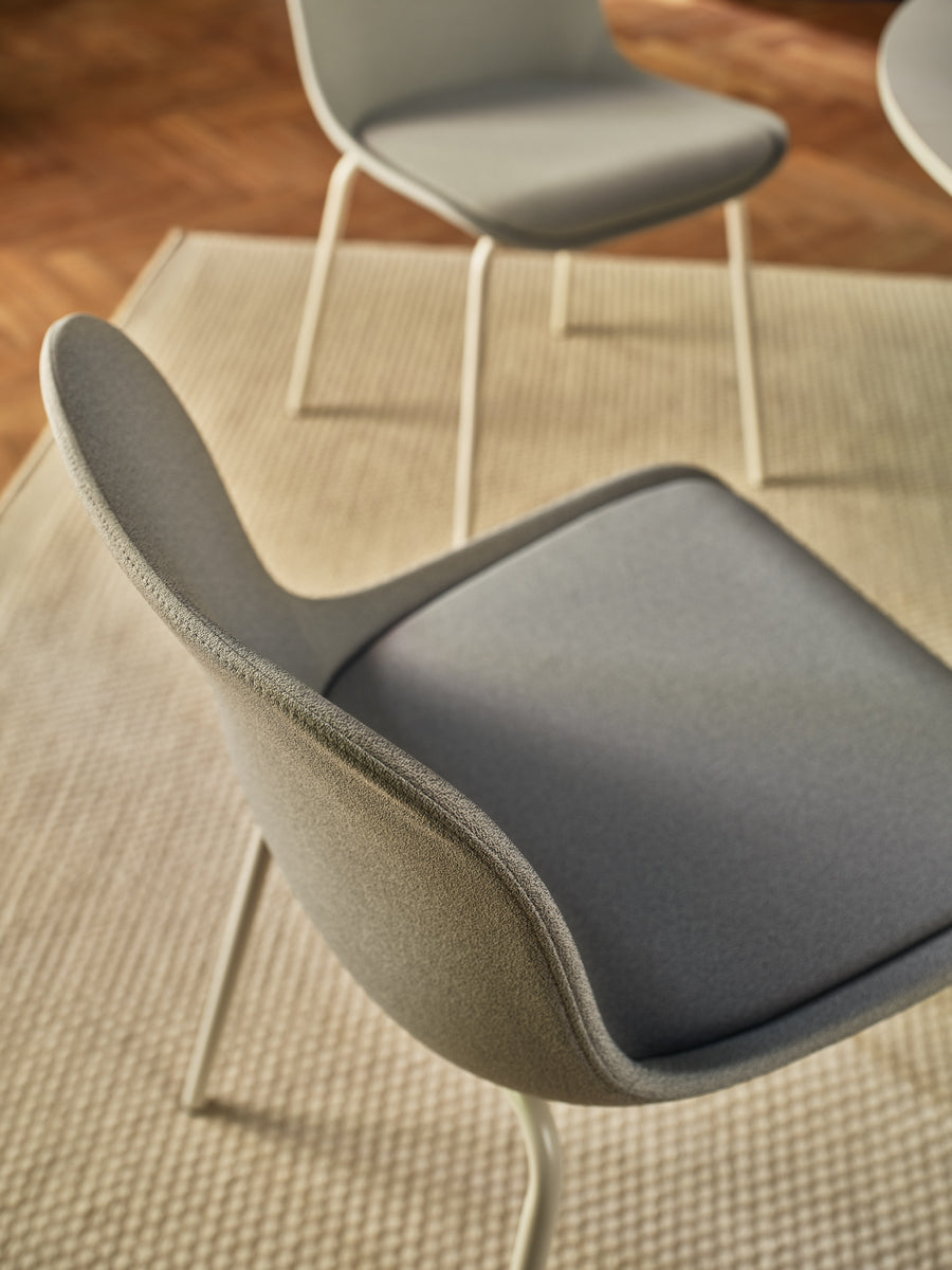 Stuhl Baltic 2 Classic von Mdd mit gepolstertem Kunststoffsitz in Dunkelbeige und 4-Bein-Gestell aus pulverbeschichtetem Metall.