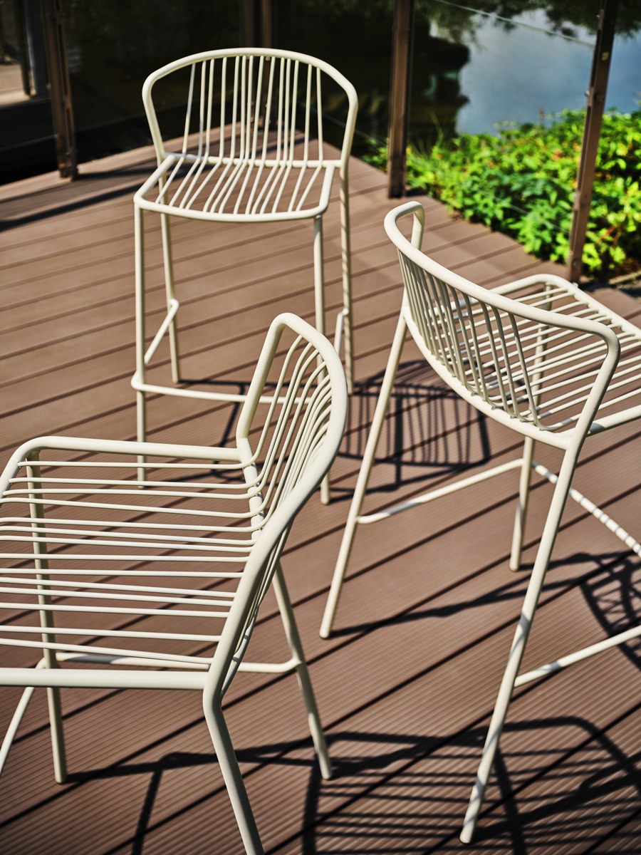 Zwei Barhocker mit durchbrochenem Sitz und Rückenlehne aus verzinktem Stahldraht, olivgrünes Gestell, schwarze Kunststofffüsse, Outdoor-Design.