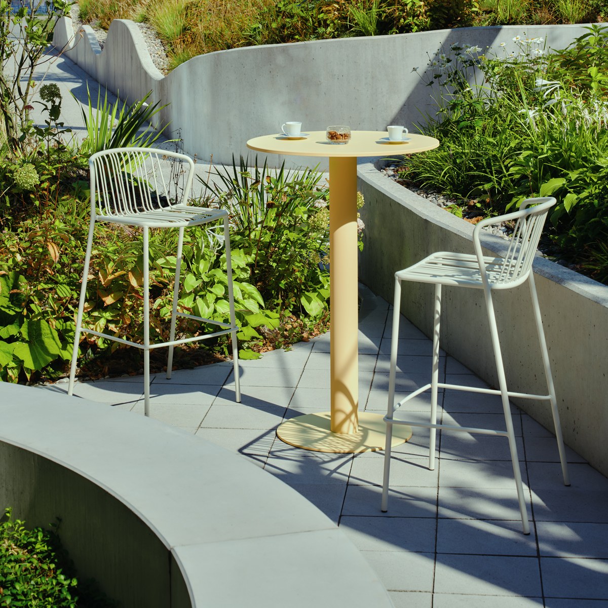 Zwei Barhocker mit durchbrochenem Sitz und Rückenlehne aus verzinktem Stahldraht, olivgrünes Gestell, schwarze Kunststofffüsse, Outdoor-Design.