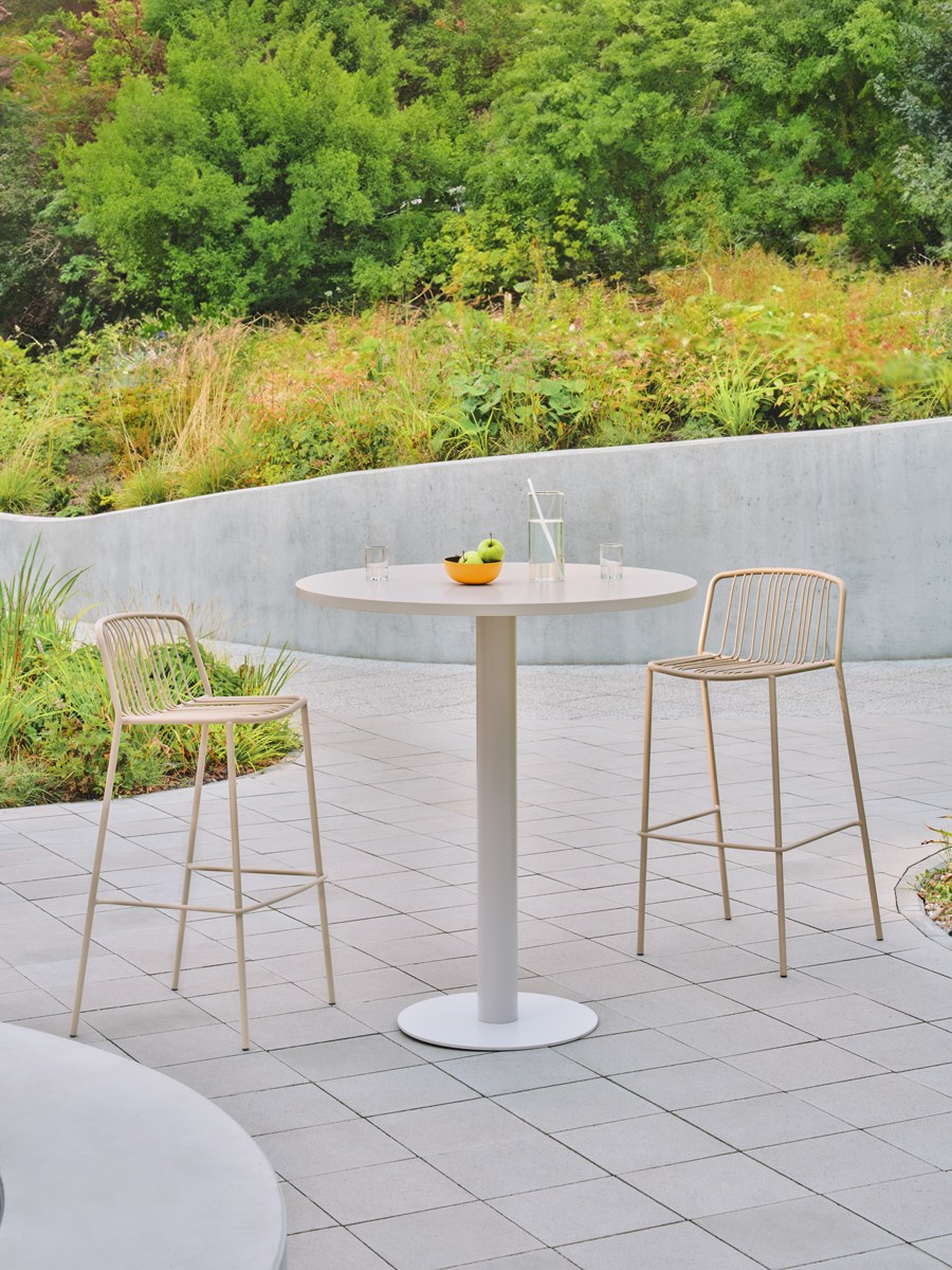 Zwei Barhocker mit durchbrochenem Sitz und Rückenlehne aus verzinktem Stahldraht, olivgrünes Gestell, schwarze Kunststofffüsse, Outdoor-Design.