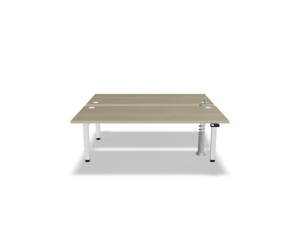Doppelschreibtisch Ogi Drive Bench in Honigeiche mit schwarzem Metallgestell, zwei Teleskopsäulen und Bedienfeldern für Höhenverstellung.
