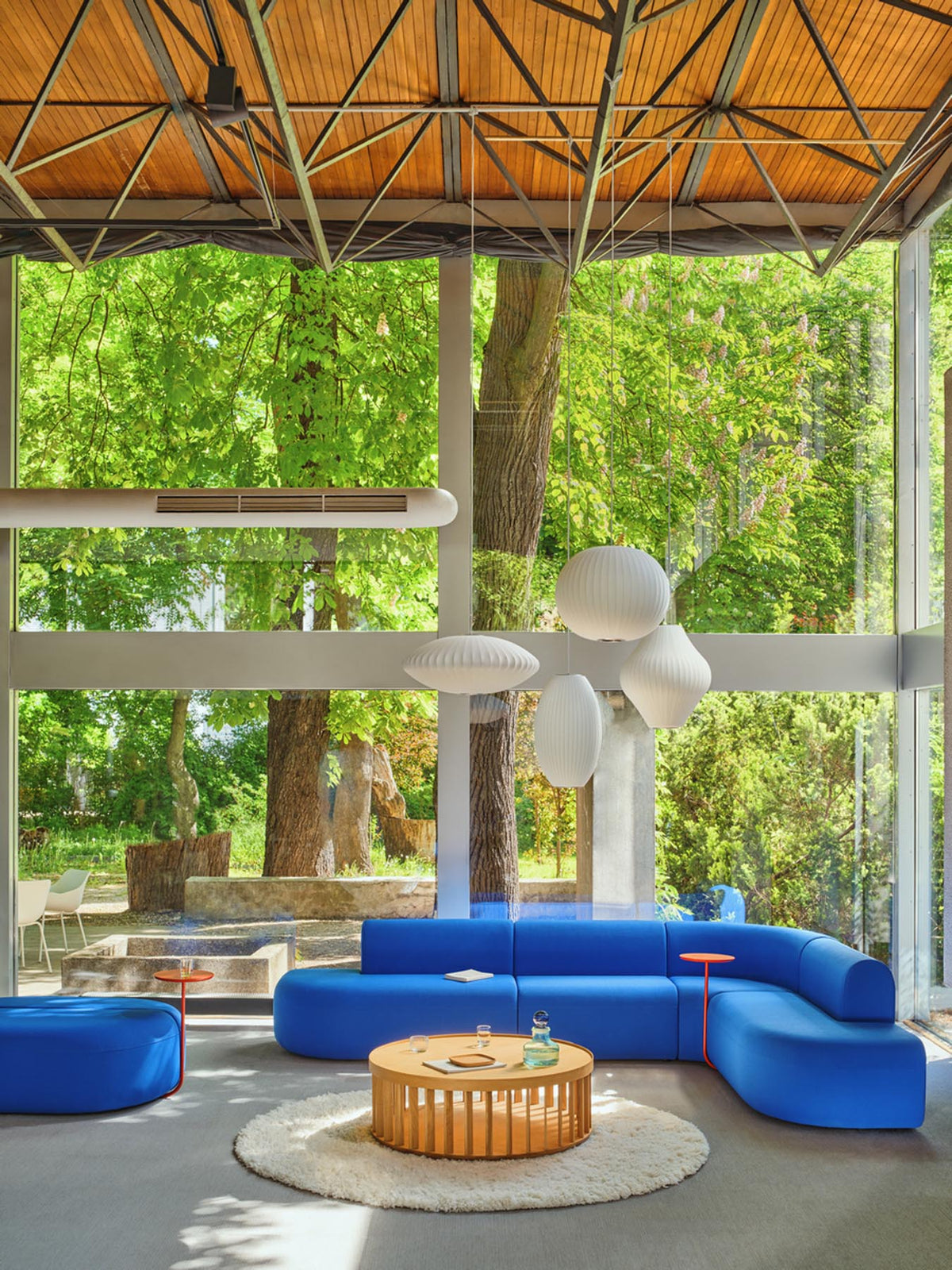 Hocker Artiko von Mdd, gepolsterte Sitzfläche in Himmelblau, rundes Design mit Gestell aus Spanplatte und Wellfederung.
