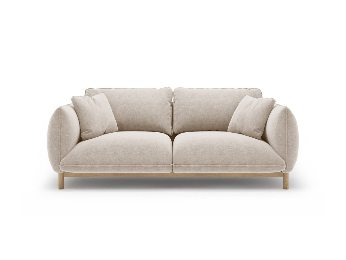 Ada 2er Sofa von Micadoni in Mandel beige mit gepolstertem Velours-Bezug, geschwungener Rückenlehne und sichtbaren Buchenholzbeinen.