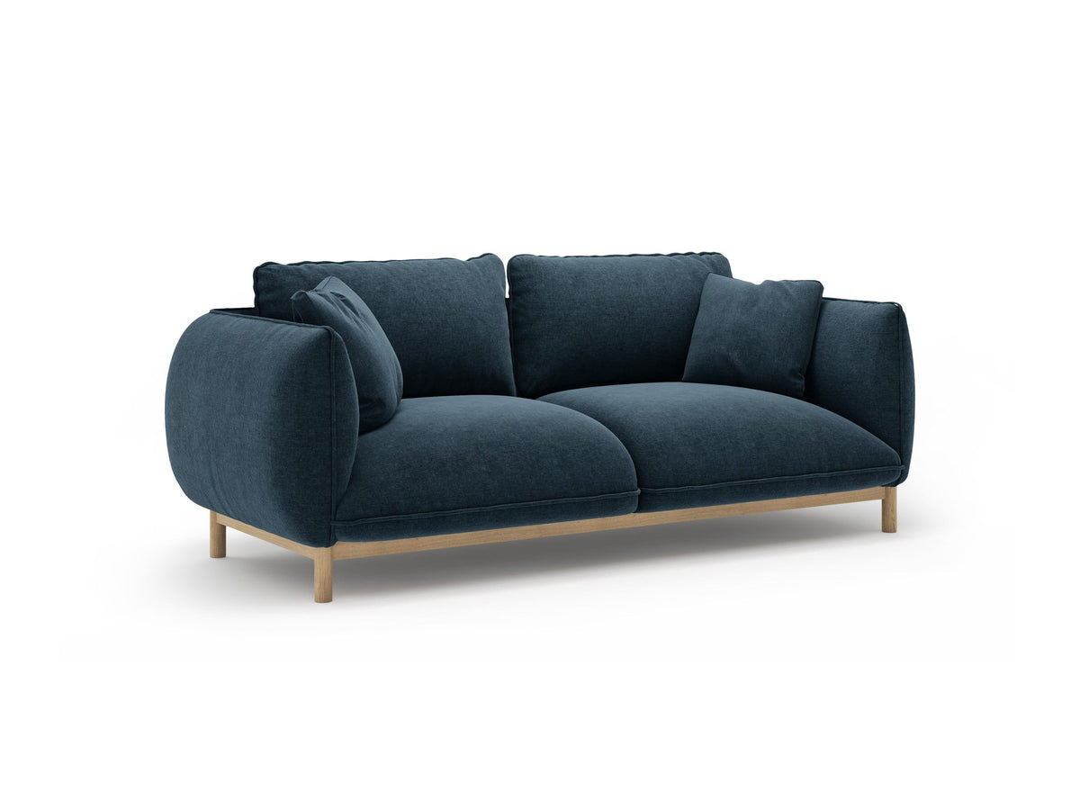 Ada 2er Sofa von Micadoni in Mandel beige mit gepolstertem Velours-Bezug, geschwungener Rückenlehne und sichtbaren Buchenholzbeinen.