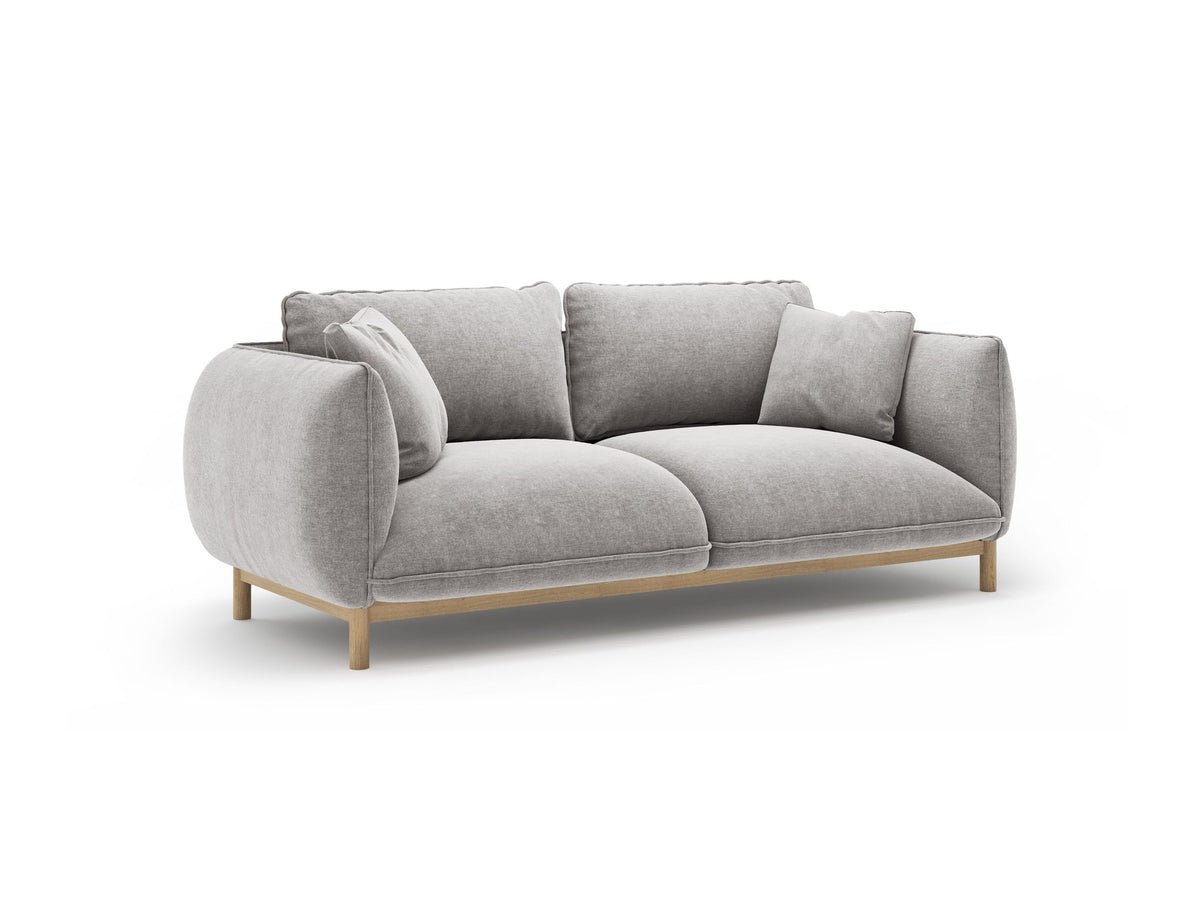 Ada 2er Sofa von Micadoni in Mandel beige mit gepolstertem Velours-Bezug, geschwungener Rückenlehne und sichtbaren Buchenholzbeinen.