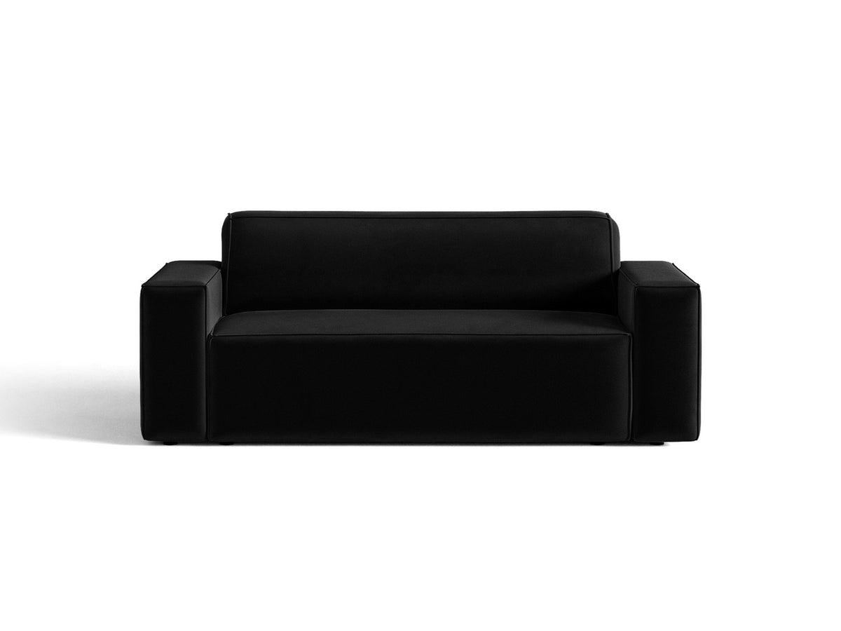 Zweisitzer-Sofa Jodie von Micadoni mit beigem Samtbezug, schwarzen Kunststoffbeinen und gepolsterter Rückenlehne, Frontalansicht.
