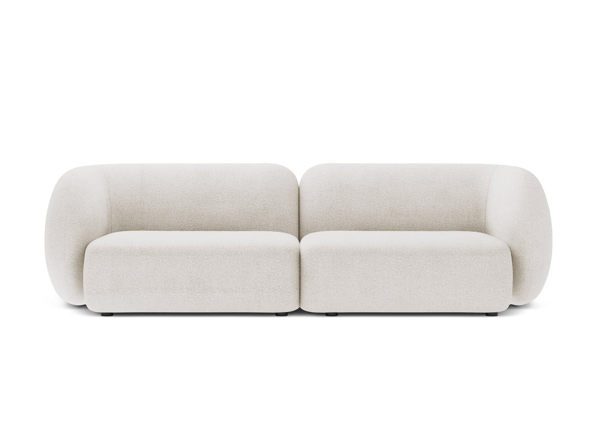 Weisses 4er Sofa Kate von Micadoni mit strukturiertem Bouclé-Stoff, schwarzen Kunststoffbeinen und breiter Sitzfläche.
