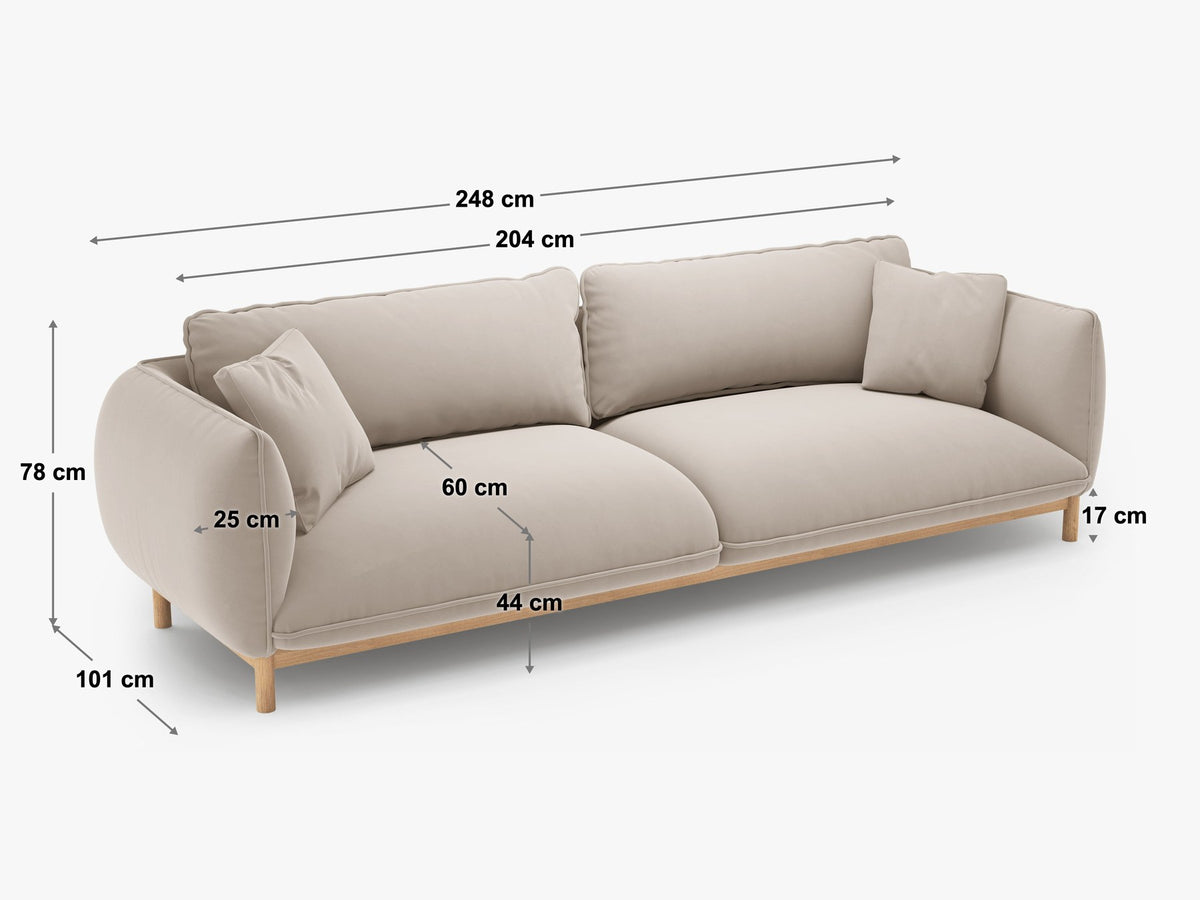 Vierersofa Ada von Micadoni in Mandel beige mit Casino-Stoffbezug, gerundeten Armlehnen und sichtbarem Buchenholzgestell auf Holzbeinen.