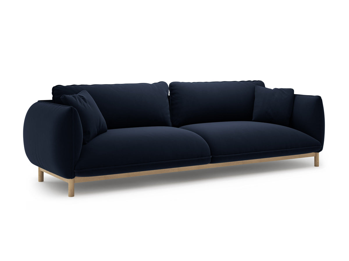 Vierersofa Ada von Micadoni in Mandel beige mit Casino-Stoffbezug, gerundeten Armlehnen und sichtbarem Buchenholzgestell auf Holzbeinen.