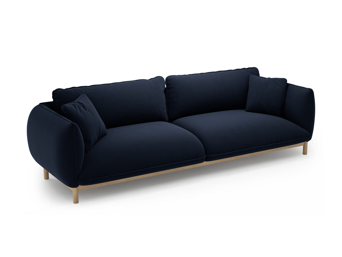 Vierersofa Ada von Micadoni in Mandel beige mit Casino-Stoffbezug, gerundeten Armlehnen und sichtbarem Buchenholzgestell auf Holzbeinen.