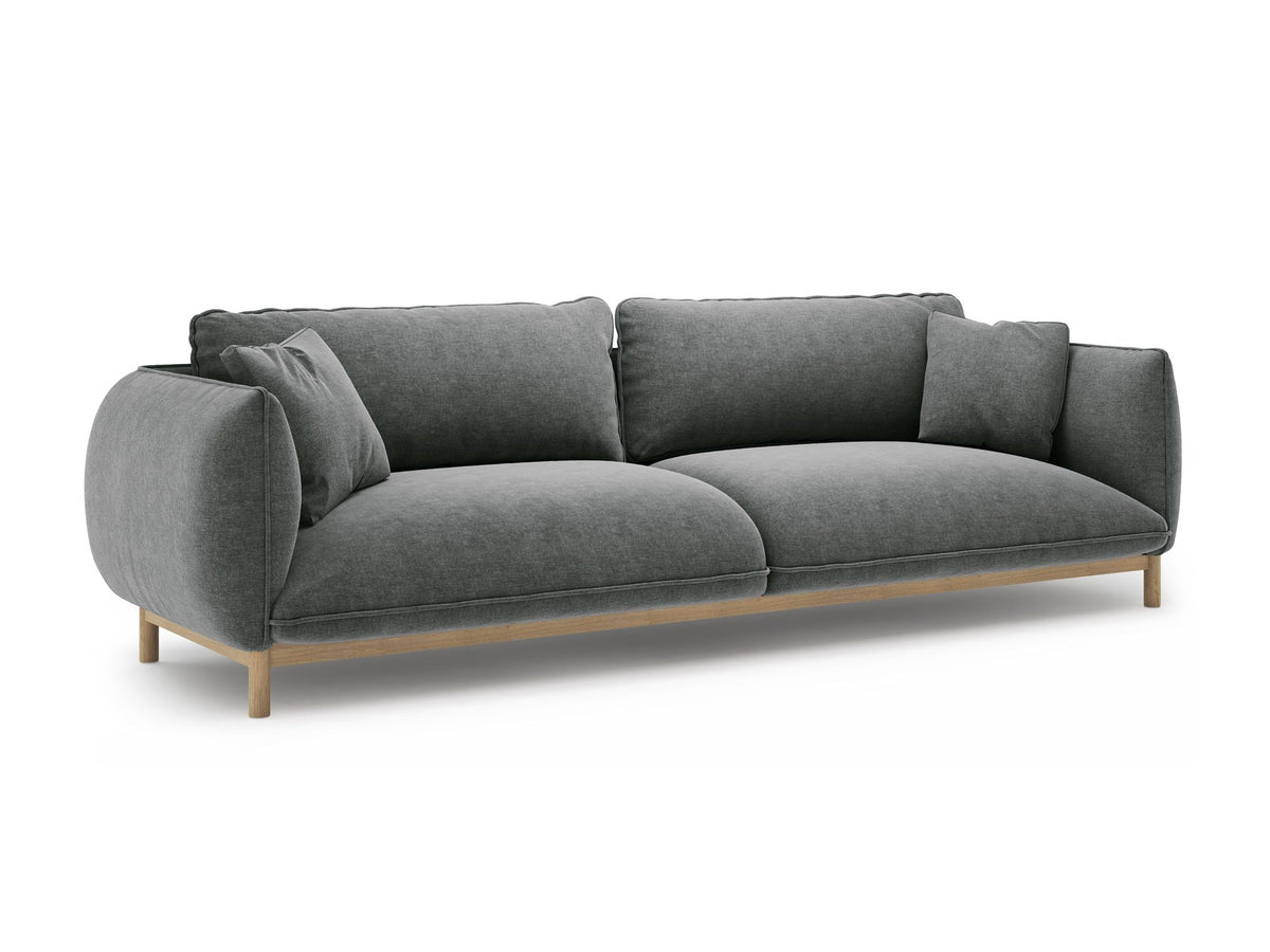 Vierersofa Ada von Micadoni in Mandel beige mit Casino-Stoffbezug, gerundeten Armlehnen und sichtbarem Buchenholzgestell auf Holzbeinen.