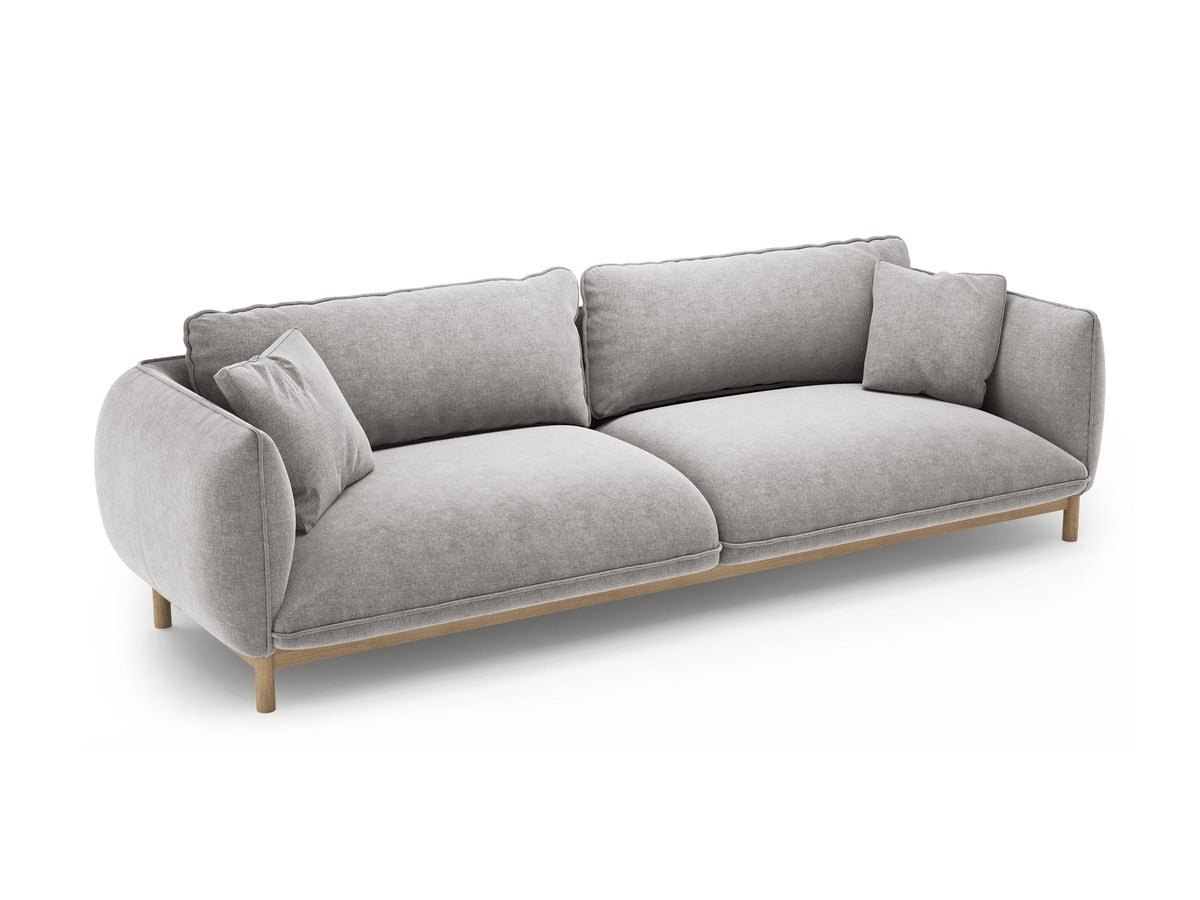 Vierersofa Ada von Micadoni in Mandel beige mit Casino-Stoffbezug, gerundeten Armlehnen und sichtbarem Buchenholzgestell auf Holzbeinen.