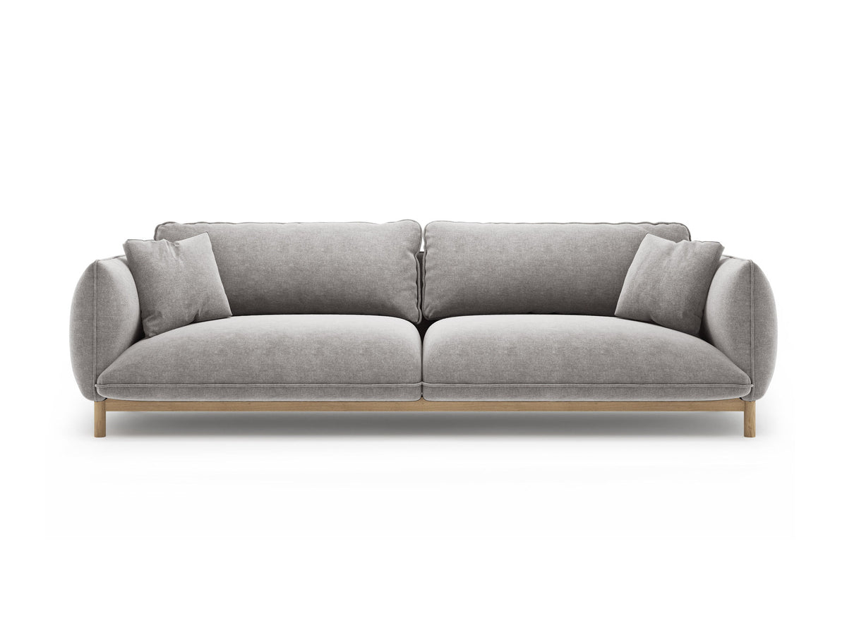 Vierersofa Ada von Micadoni in Mandel beige mit Casino-Stoffbezug, gerundeten Armlehnen und sichtbarem Buchenholzgestell auf Holzbeinen.