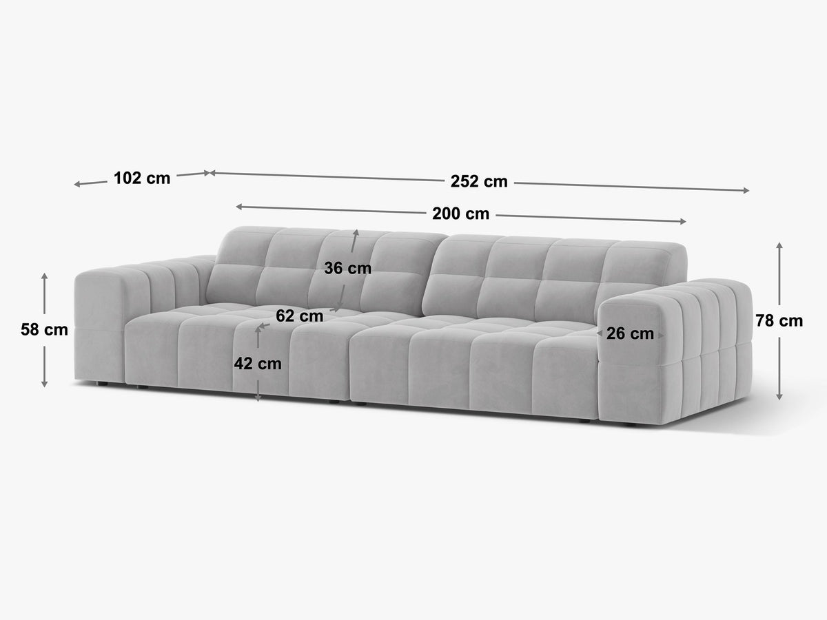 Beigefarbenes 4er Sofa Jennifer von Micadoni mit Samt-ähnlichem Bluvel-Stoff, schwarzen Kunststoffbeinen und gerader Rückenlehne.
