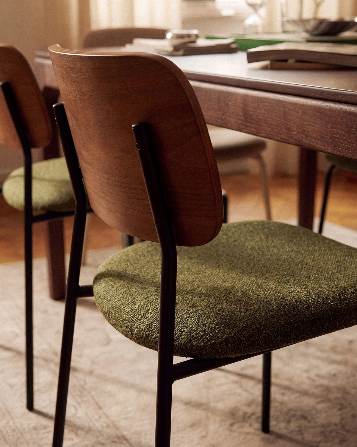 Beiger Samtstuhl mit gepolstertem Sitz aus Bouclé-Stoff, ergonomischer Rückenlehne aus Buchenholz und schwarzen Stahlbeinen im Esszimmer.
