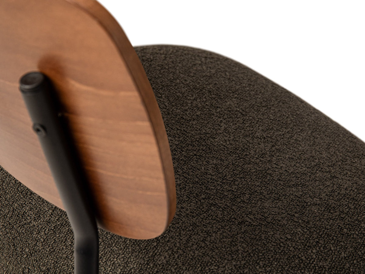 Beiger Samtstuhl mit gepolstertem Sitz aus Bouclé-Stoff, ergonomischer Rückenlehne aus Buchenholz und schwarzen Stahlbeinen im Esszimmer.