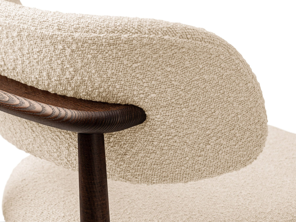 Beige gepolsterter Stuhl mit dick strukturiertem Bouclé-Stoff, gerader Rückenlehne und vier Beinen aus Nussbaumholz, Frontalansicht.