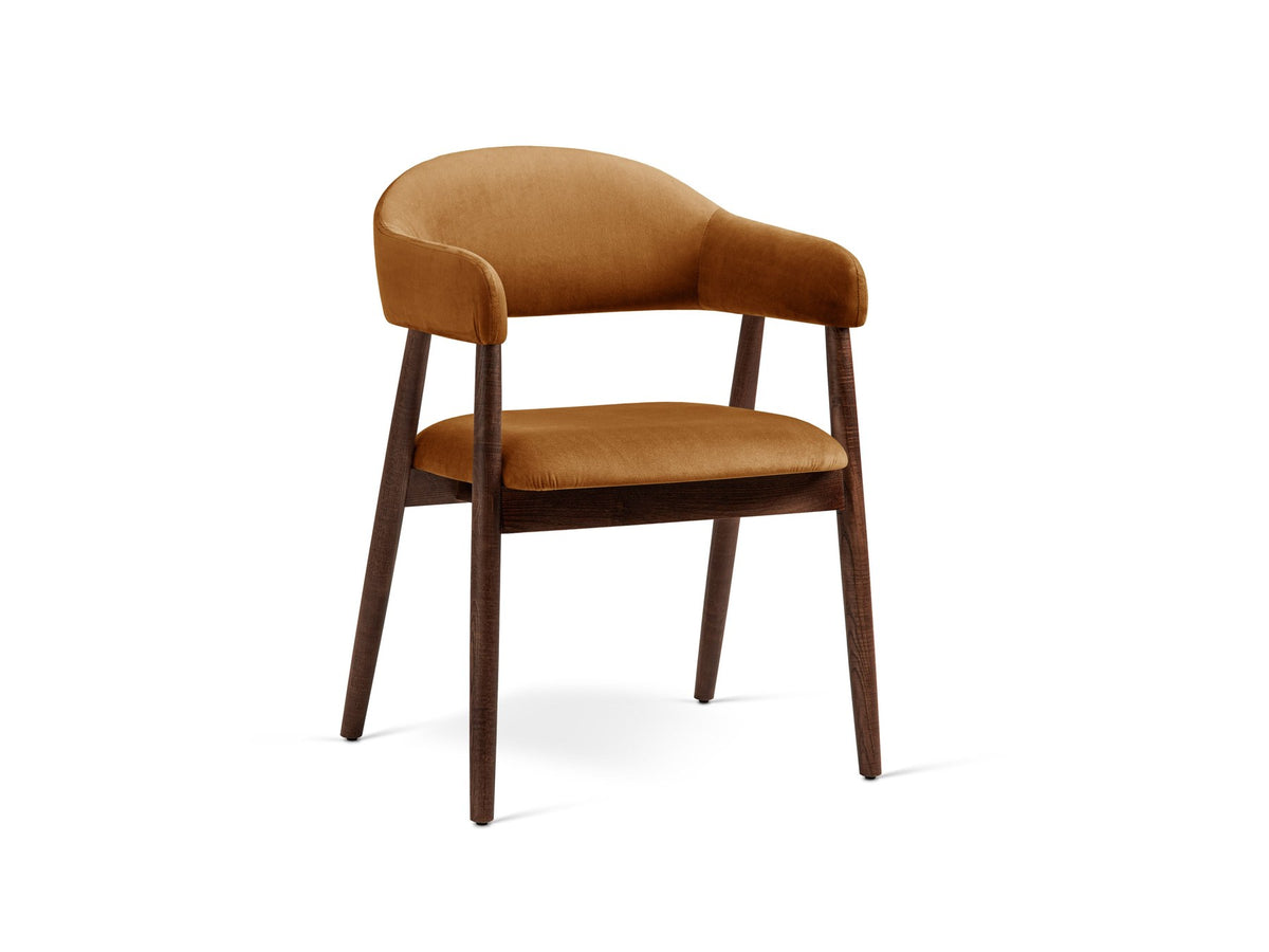 Foto vom Adra Samtstuhl in Mandel beige mit weichem Samtbezug, gepolsterter Sitzfläche und Beinen aus Nussbaum-Holz.