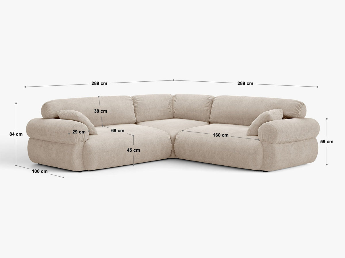 Beiges Ecksofa Ophelia von Micadoni mit Liberty-Stoff, schwarzen Kunststoffbeinen und niedriger, symmetrischer Silhouette im Wohnzimmer.