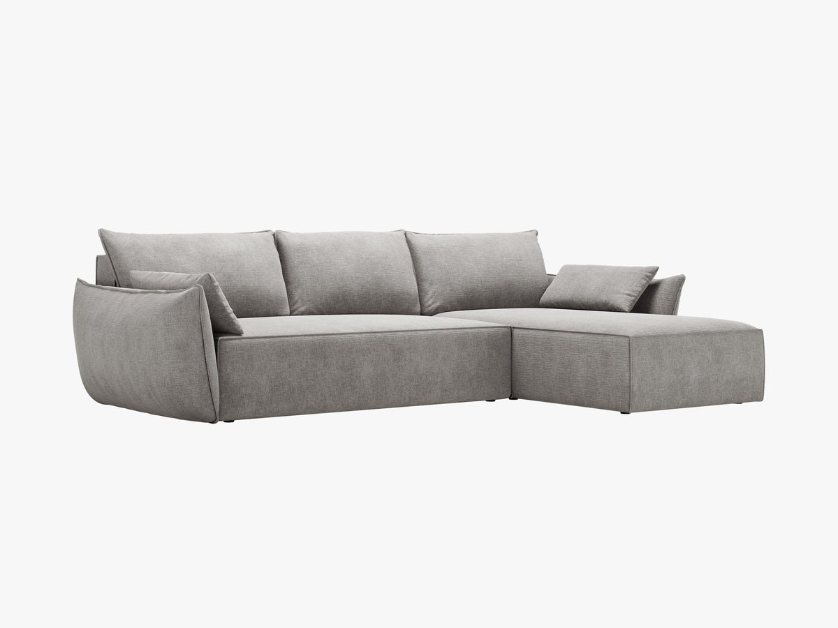 Linksseitiges Ecksofa Kaelle von Micadoni in leichtem Beige mit Chenille-Stoffbezug, schwarzen Kunststoffbeinen und ausklappbarem Bettkasten.