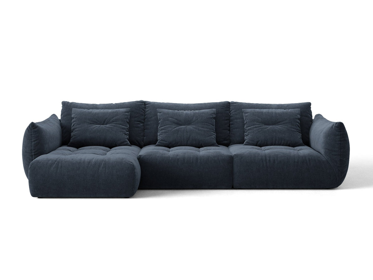 Beiges L-Sofa links von Micadoni mit weichem Veloursstoff Casino, schwarzen Kunststoffbeinen und breiter, tiefer Sitzfläche.