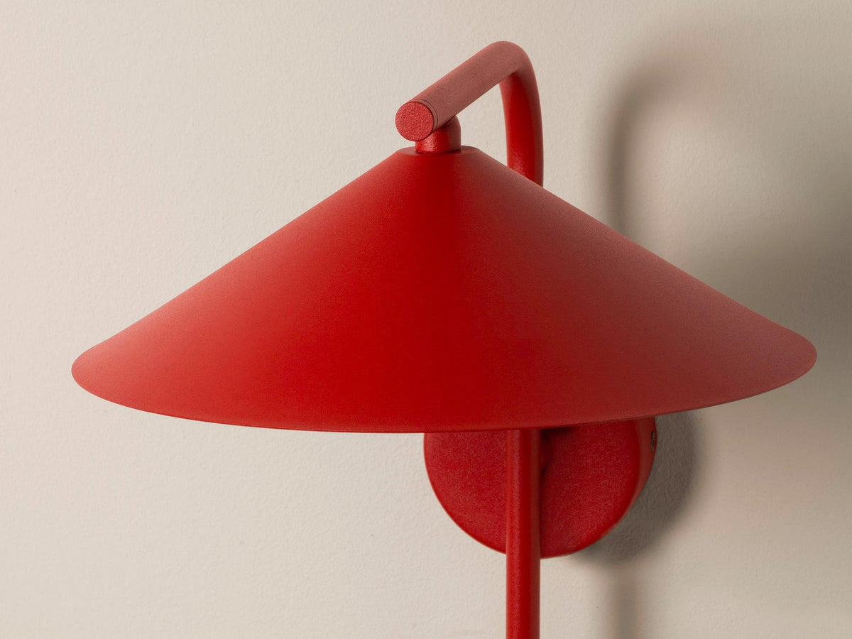 Wandlampe Nocte von Micadoni in Burgundfarben, konische Form aus mattem Metall, montiert an einer hellen Wand im Wohnraum.